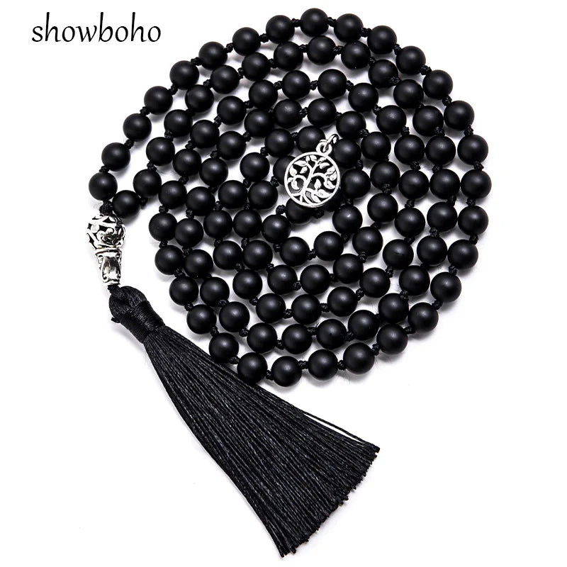 Collier mala 108 perles noires mates enroulé en spirale, avec pampille arbre de vie argentée au centre et pompon noir