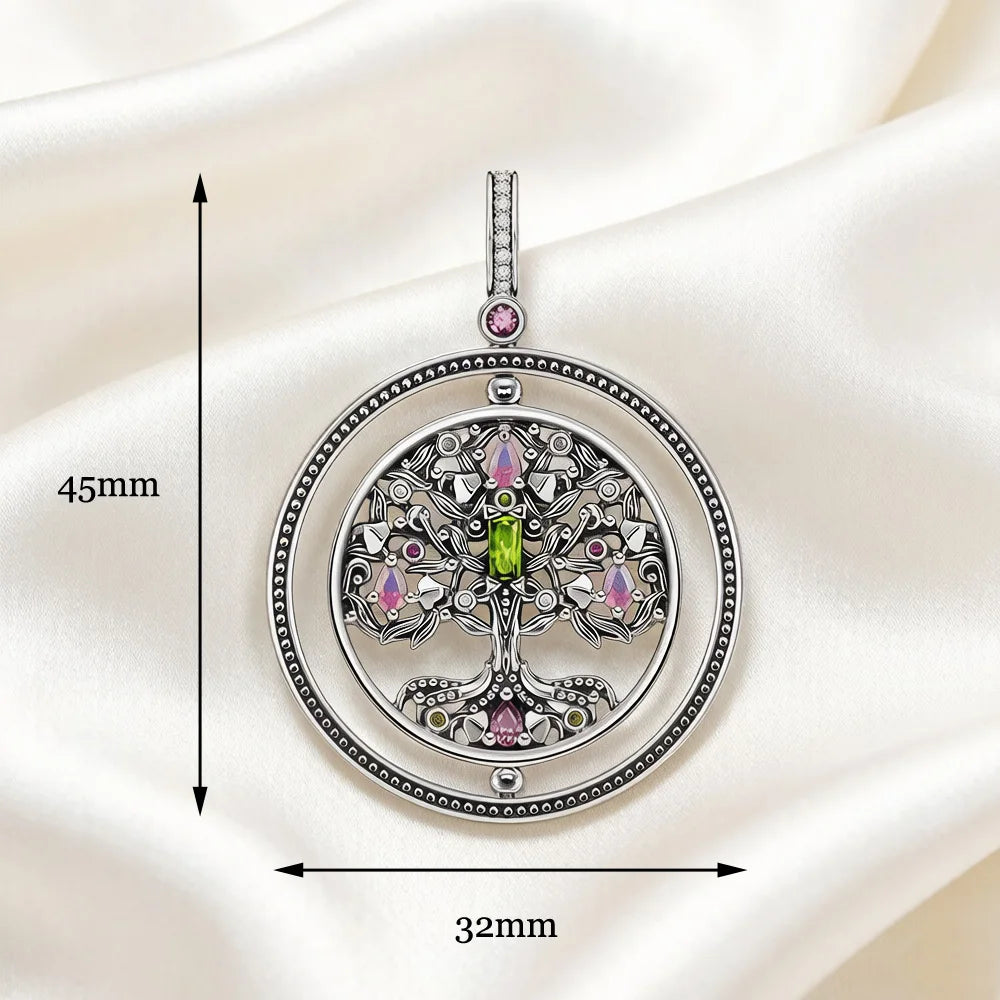 Pendentif Arbre de Vie Rotatif en argent porté autour du cou, gros plan sur le bijou orné de pierres colorées roses et vertes