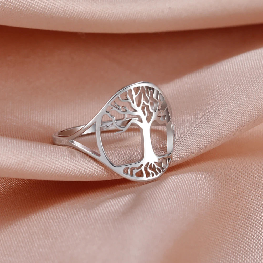 Bague fine Arbre de Vie en acier argenté, motif arbre ajouré, posée sur un tissu rose poudré
