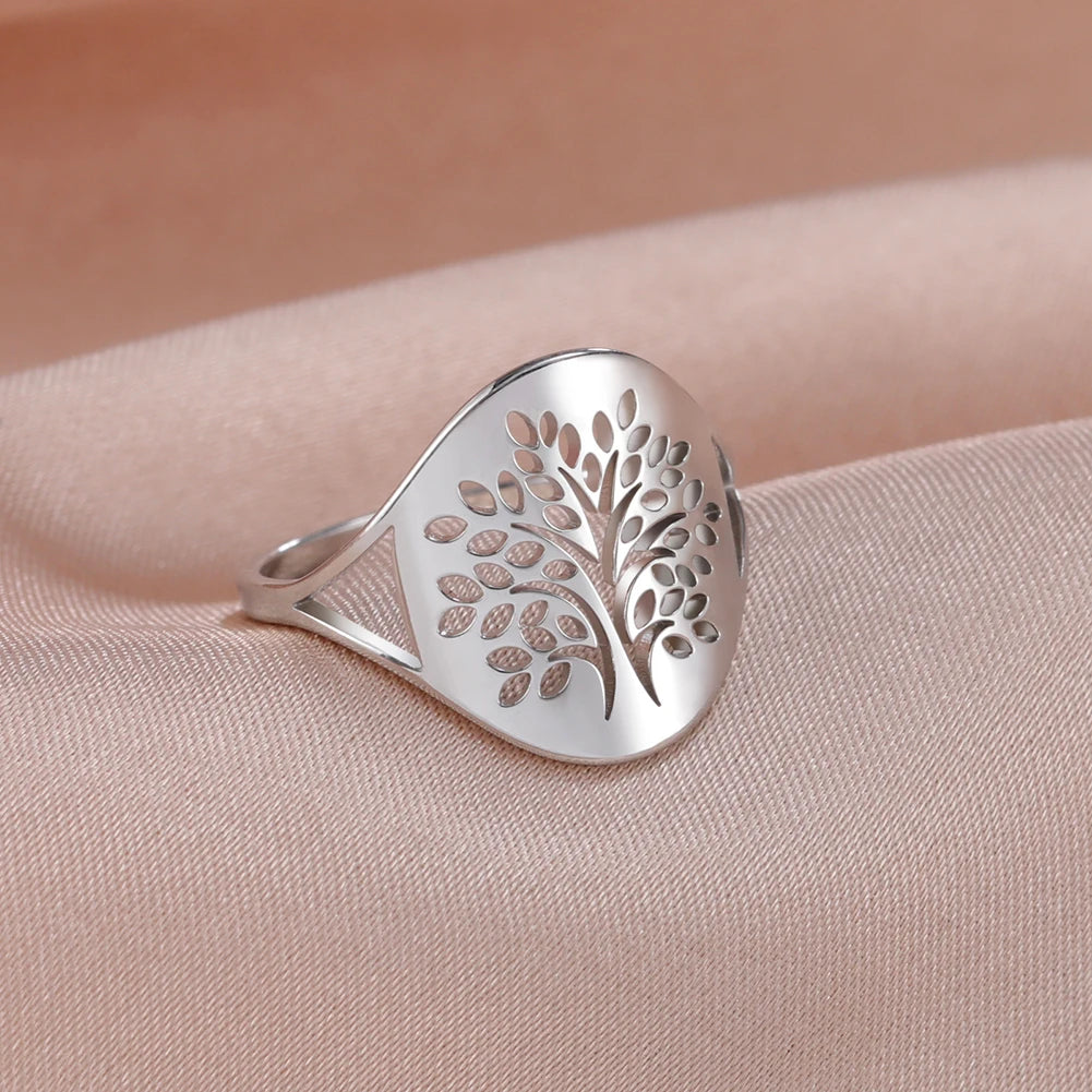 Bague fine Arbre de Vie en acier argenté, motif feuillage ajouré, posée sur un tissu rose poudré