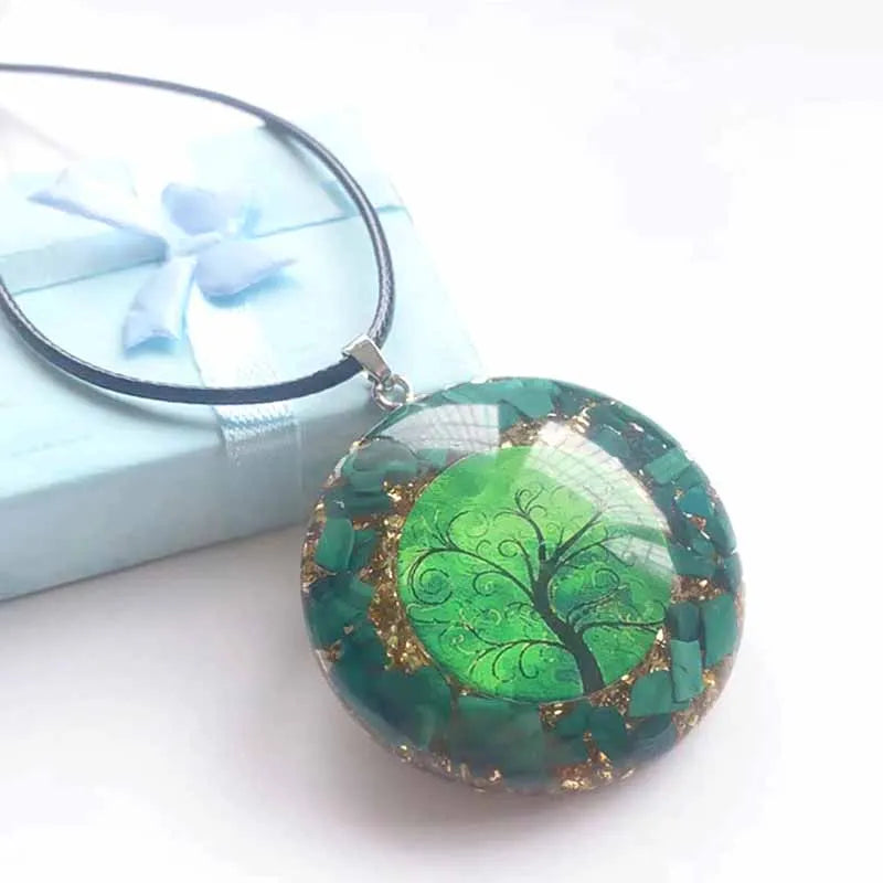 Collier pendentif Arbre de Vie en résine verte et éclats de malachite, posé devant son coffret cadeau turquoise à ruban
