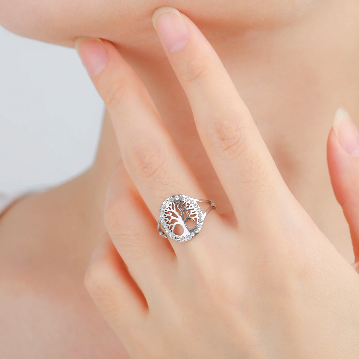 Bague Arbre de Vie en acier argenté ornée de strass, portée au doigt par un modèle