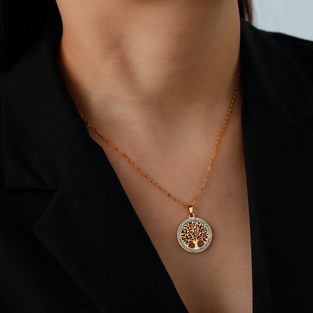 Pendentif Arbre de Vie doré serti de strass, porté au cou sur une veste noire