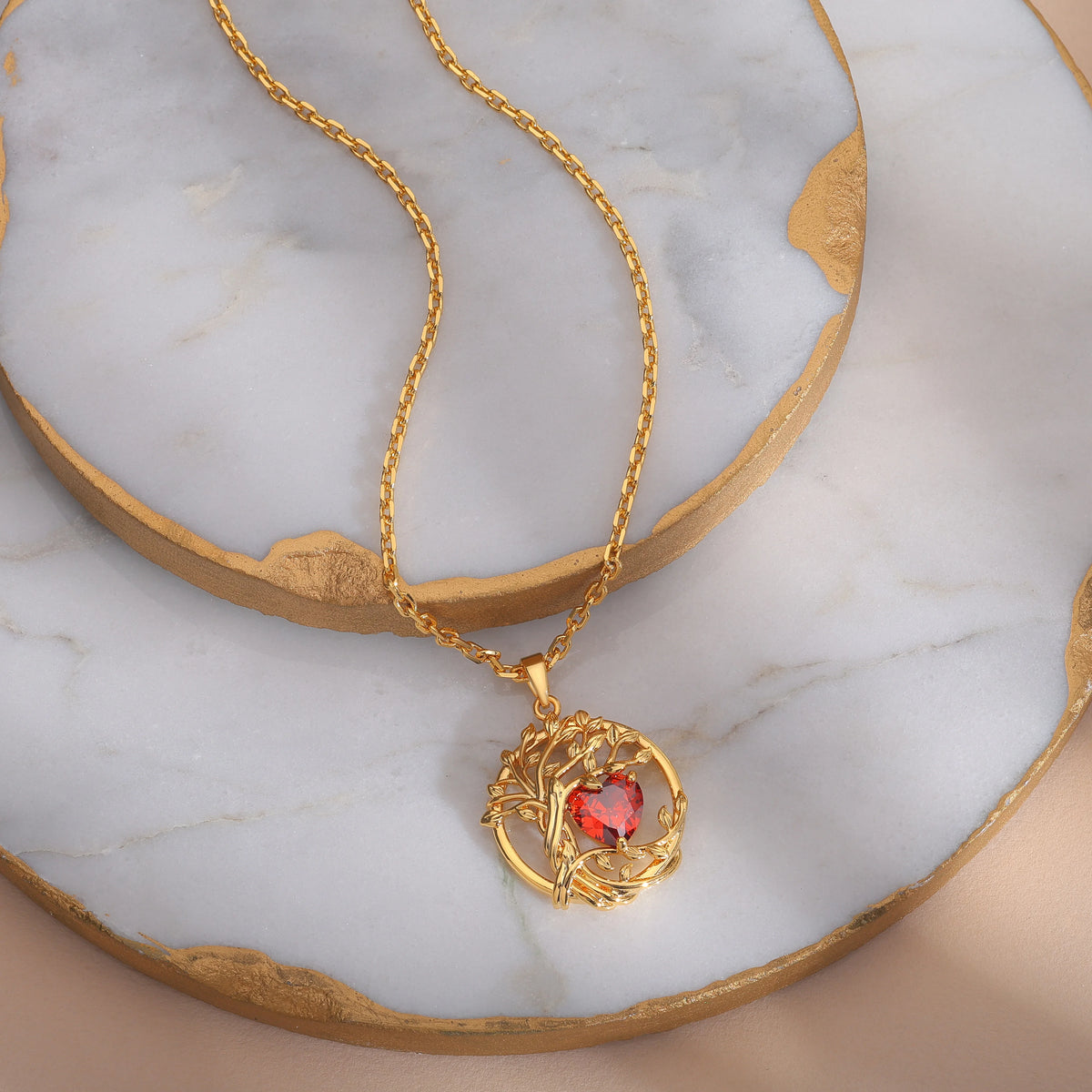 Collier Arbre de Vie en argent 925 finition dorée, pendentif avec arbre doré et pierre cœur rouge, posé sur une plaque en marbre blanc et doré