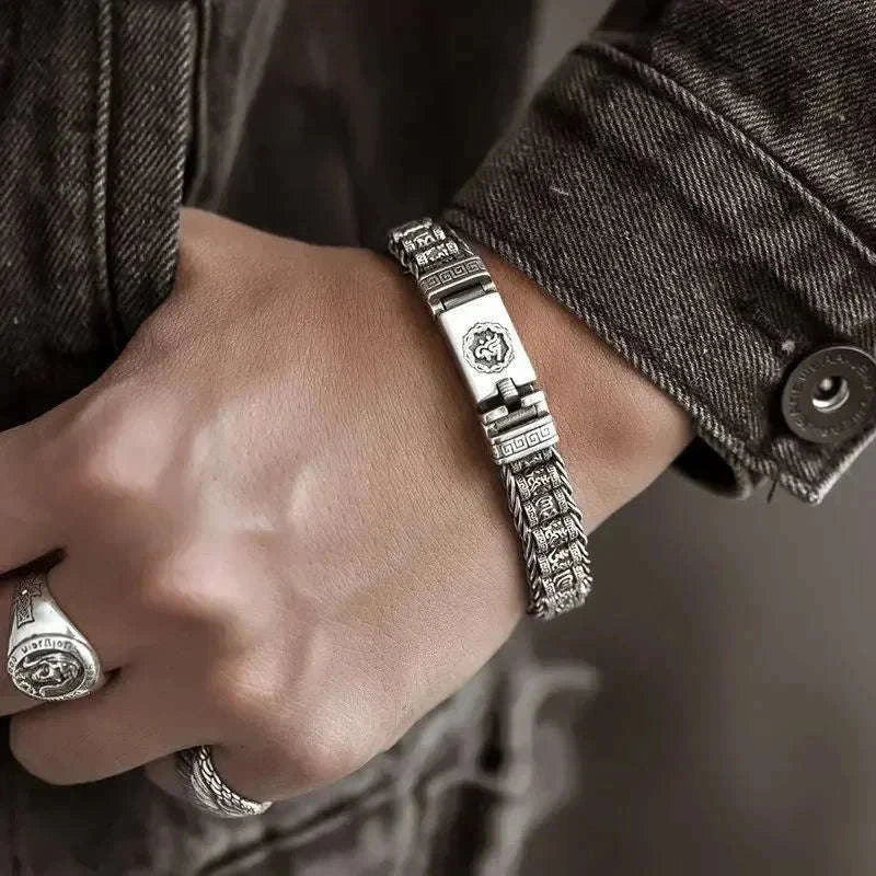 Bracelet jonc en argent porté au poignet, fermoir à cliquet visible, veste en jean